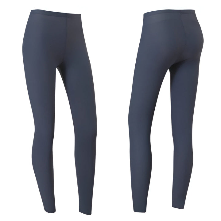 Un homme porte un short gris et blanc avec la main dans la poche. Le short a des finitions blanches. Il porte un haut gris à manches longues.