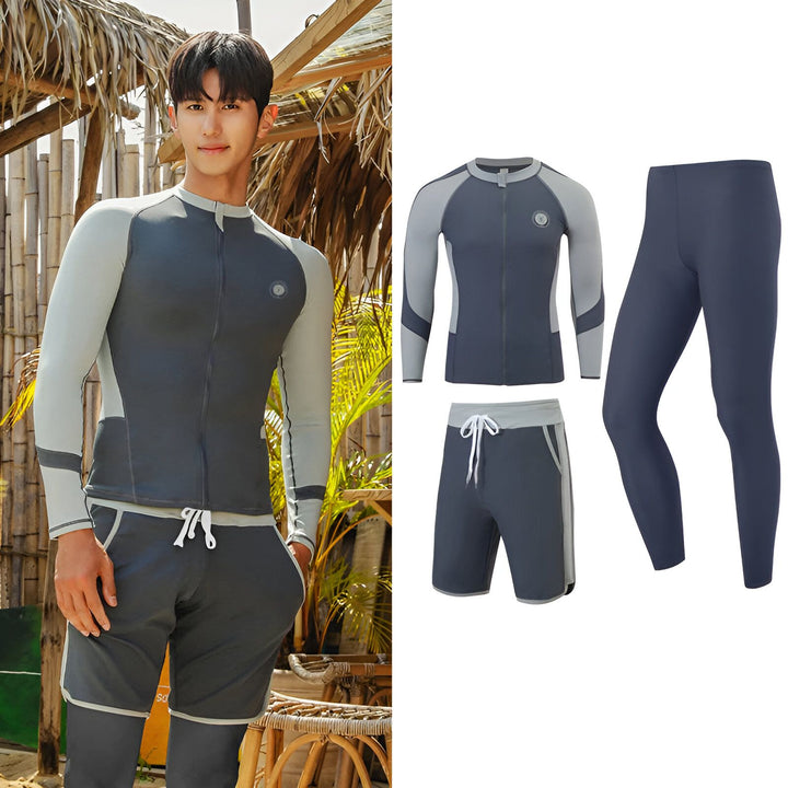 Un jeune homme asiatique souriant, portant un rashguard gris ouvert et un short de bain assorti, se tient à l'extérieur d'un bar de plage en bambou.