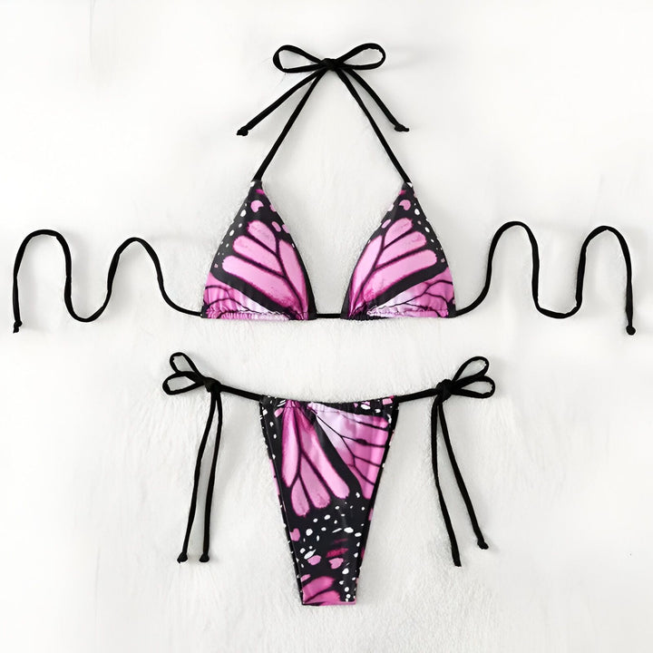 Gros plan d'une femme portant un bikini avec un motif d'aile de papillon monarque orange et noir. Le bikini est maintenu par de fines bretelles noires. Mise au point sur le haut du corps de la femme.