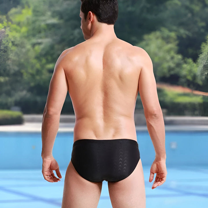 Slip de bain noir pour homme, avec un motif discret de croissants de lune. Vue arrière, idéal pour la natation et les activités aquatiques.