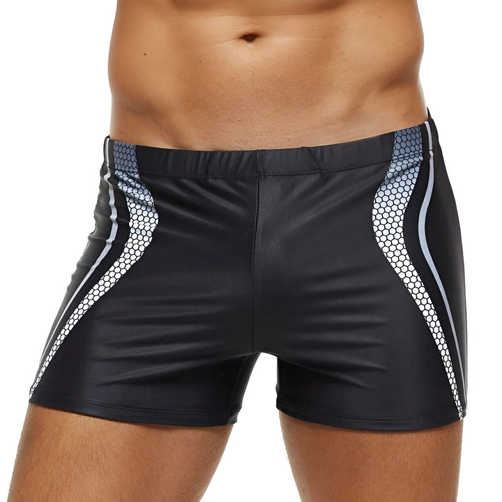 Homme torse nu en maillot de bain bleu. Le maillot est court et moulant avec des motifs blancs sur le côté. Vue de face et de dos.