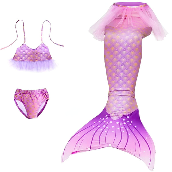 Une personne assise sur une chaise, portant un costume de sirène violet avec des écailles dorées et un tutu rose.