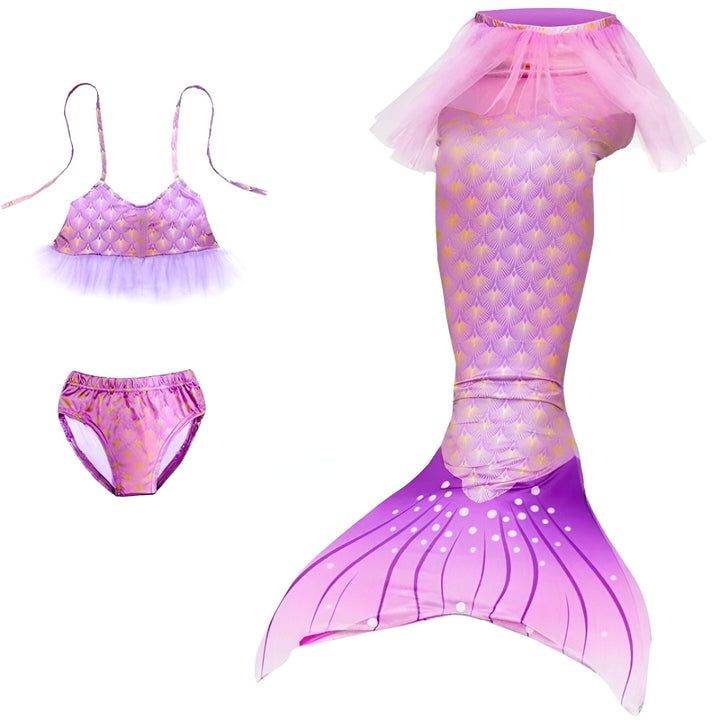 Une personne assise sur une chaise, portant un costume de sirène violet avec des écailles dorées et un tutu rose.