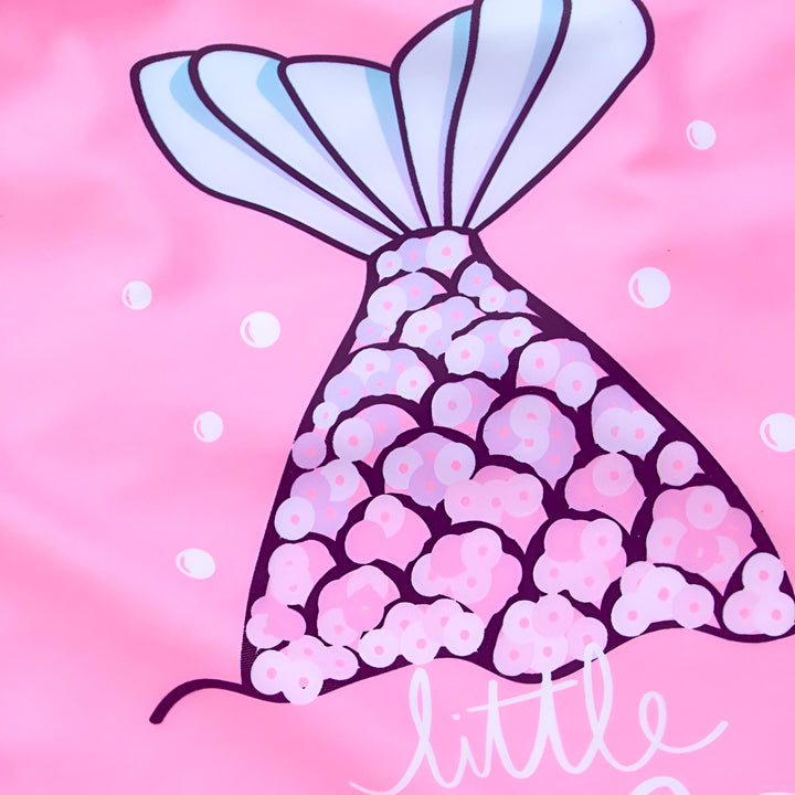 Maillot de bain rose pour enfant avec queue de sirène et l'inscription "little mermaid summer vibes". Chapeau de paille visible à gauche.
