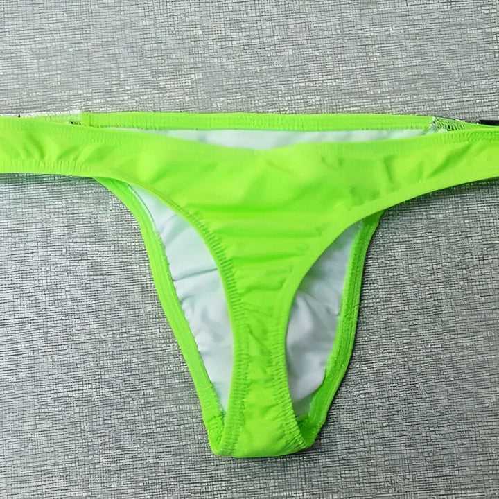Homme torse nu, portant un string de bain vert citron avec un push-up beige. Mode masculine, sous-vêtement homme.