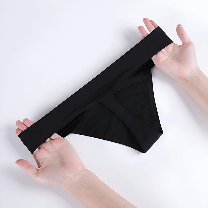 Culotte noire sans couture tenue par deux mains, fond blanc.