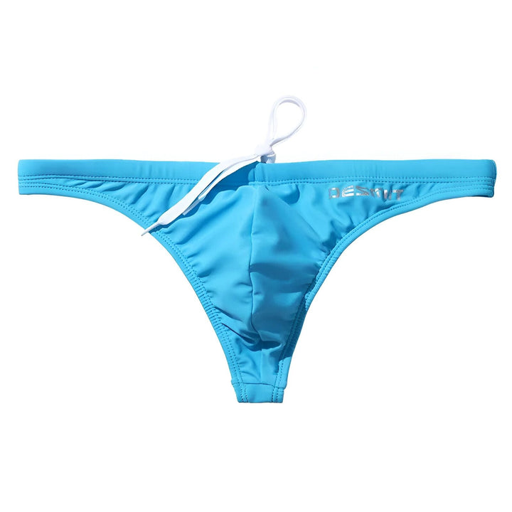 Homme portant un slip de bain bleu clair de la marque DESMIIT. Le maillot de bain met en valeur le torse de l'homme. Vêtements de plage et sous-vêtements pour hommes.