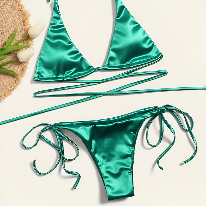 Image d'un bikini triangle doré brillant avec des liens fins, parfait pour l'été et les vacances.