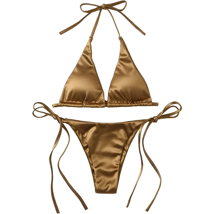 Un bikini en satin vert émeraude avec des liens fins, posé à plat avec un chapeau de paille et des tulipes blanches à côté.