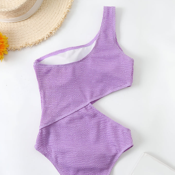 Maillot de bain une pièce vert fluo asymétrique avec chapeau de paille et fleur. Vêtement de plage tendance pour l'été. Idée de look estival.