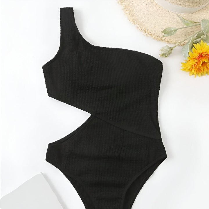 Image d'un maillot de bain une pièce vert fluo avec une découpe sur le côté, un chapeau de paille et une fleur jaune en arrière-plan. Idéal pour les vacances à la plage et les journées ensoleillées.