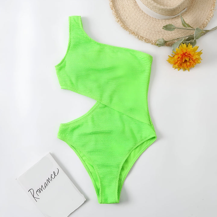 Vue de dessus d'un maillot de bain une pièce vert vif avec une découpe sur le côté, des lunettes de soleil vertes et un chapeau de paille. Style estival, tenue de plage.