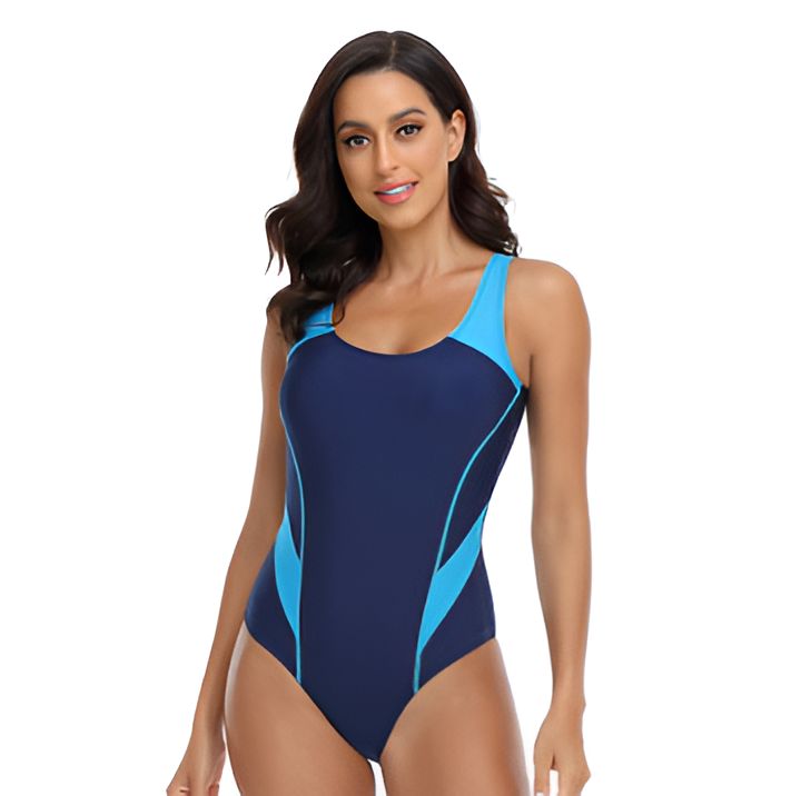 Une femme portant un maillot de bain une pièce bleu et turquoise. Elle est de dos, regardant vers la gauche. Le maillot a un dos ouvert.