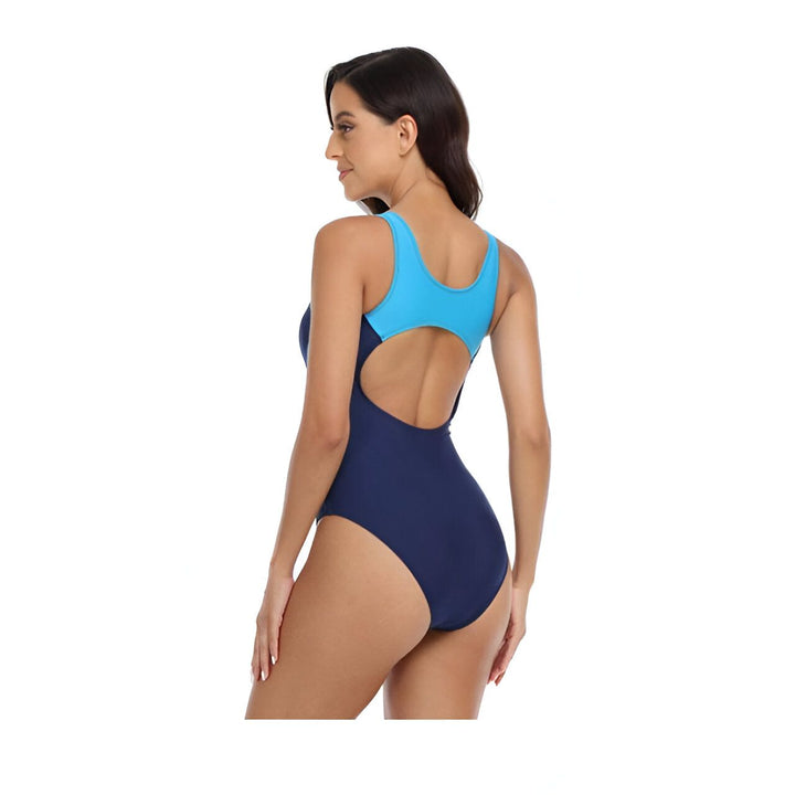 Image d'une femme portant un maillot de bain une pièce bleu marine et bleu clair. Le maillot a un design sportif avec des panneaux contrastés. Idéal pour la natation et les activités aquatiques.