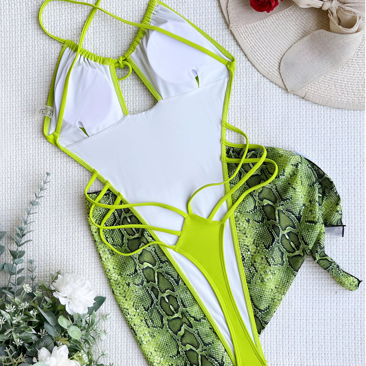 Femme en maillot de bain orange une pièce avec décolleté plongeant et détails à lacets. Jupe assortie à imprimé serpent. Style mode été, vêtements de plage.