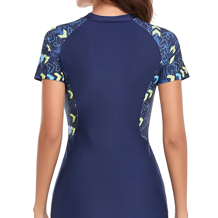 Vue arrière d'une femme portant un maillot de bain noir avec des motifs colorés sur les manches. Combinaison de bain une pièce à manches courtes. Mode été et sports aquatiques.