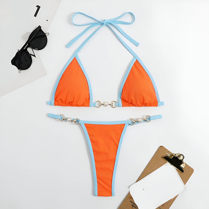 Vue aérienne d'un bikini orange et bleu ciel avec lunettes de soleil noires et presse-papiers marron.