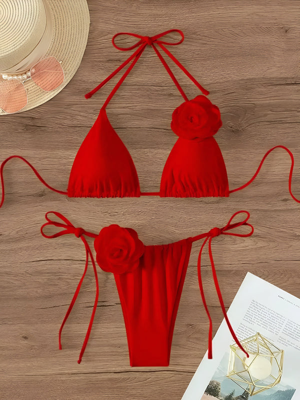 Image d'un bikini rose vif avec des détails floraux, présenté sur un fond en bois, parfait pour la mode estivale et les tendances plage.