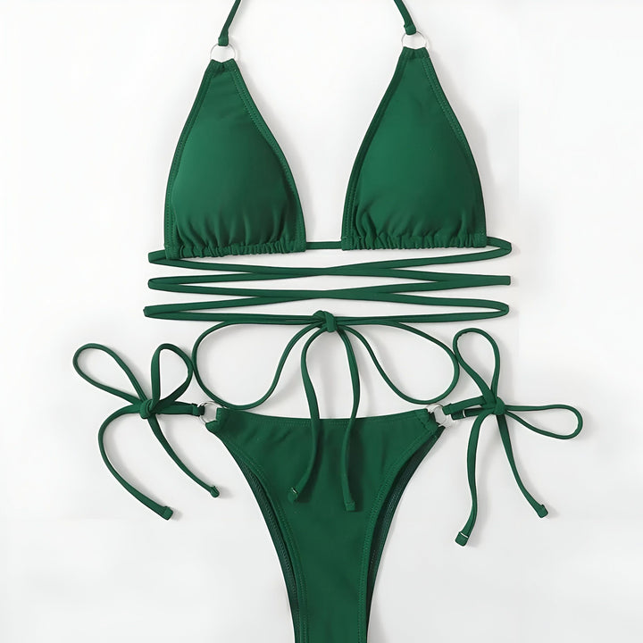 Une femme portant un bikini rose vif, un collier avec un pendentif en forme d'Afrique. Maillot de bain tendance, collection été. Mode plage.