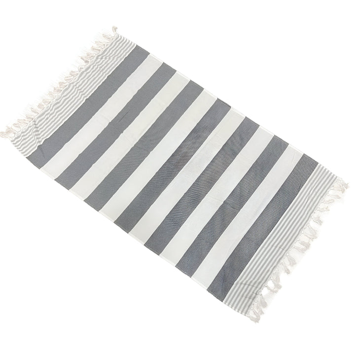 Serviettes de plage turques à rayures grises et blanches avec des franges, pliées en diagonale. Serviette légère et absorbante, idéale pour la plage ou la piscine.