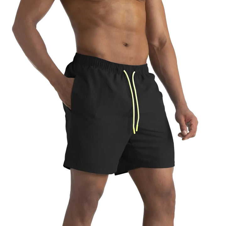 Détail d'un short de sport vert foncé avec cordon jaune à pois, mettant en valeur la texture du tissu et le design des cordons de serrage.