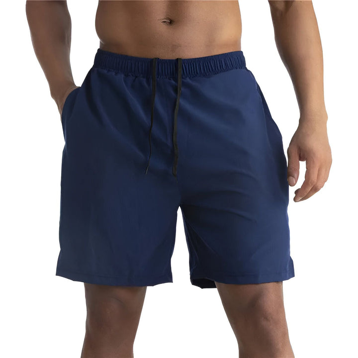 Homme torse nu portant un short de sport rouge avec cordon noir à la taille et poches. Vêtement décontracté, idéal pour l'entraînement physique.