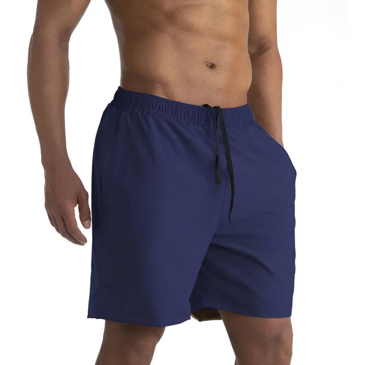 Homme athlétique en short de sport rouge à double épaisseur, avec poche latérale noire contenant un téléphone connecté avec des écouteurs. Idéal pour la course et le fitness.