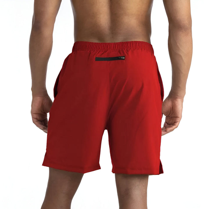 Homme mettant un téléphone dans la poche d'un short de sport bleu marine et noir.