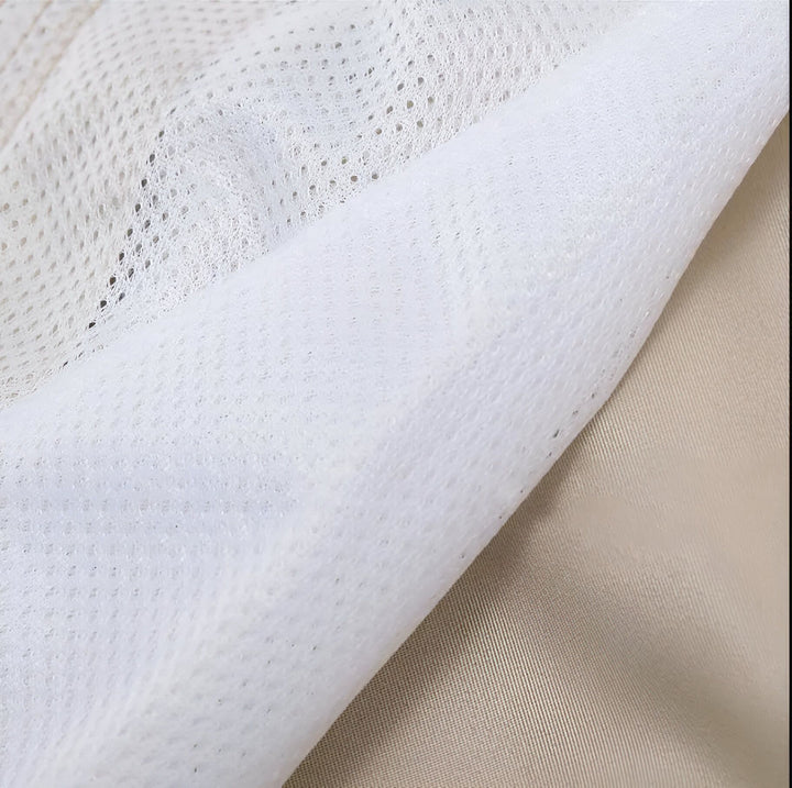 Gros plan d'un tissu beige lisse et d'une doublure en maille blanche aérée. Détail de texture de vêtement, matière respirante.