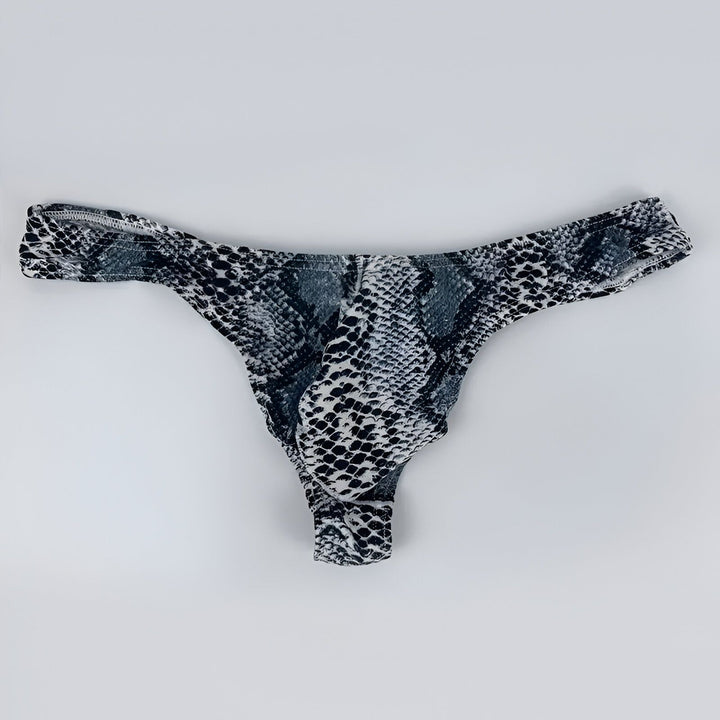 Homme portant un slip imprimé serpent vert vif. Tatuages d'hirondelles au-dessus du nombril. Style audacieux et unique. Sous-vêtement tendance. Mode masculine. Détail du corps.