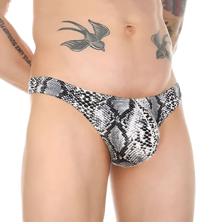 Corps masculin torse nu avec tatouage d'oiseau et portant un slip kangourou à motif peau de serpent vert et noir.